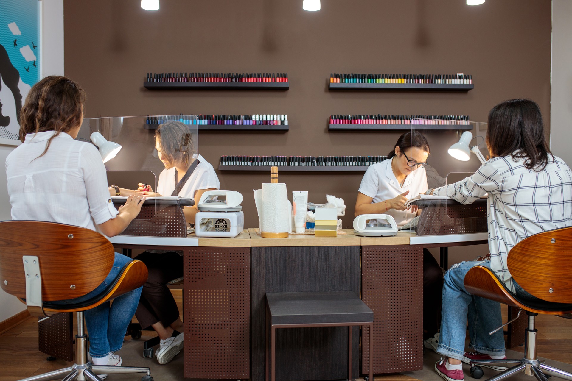 Two young female manicurists working in a nail salon